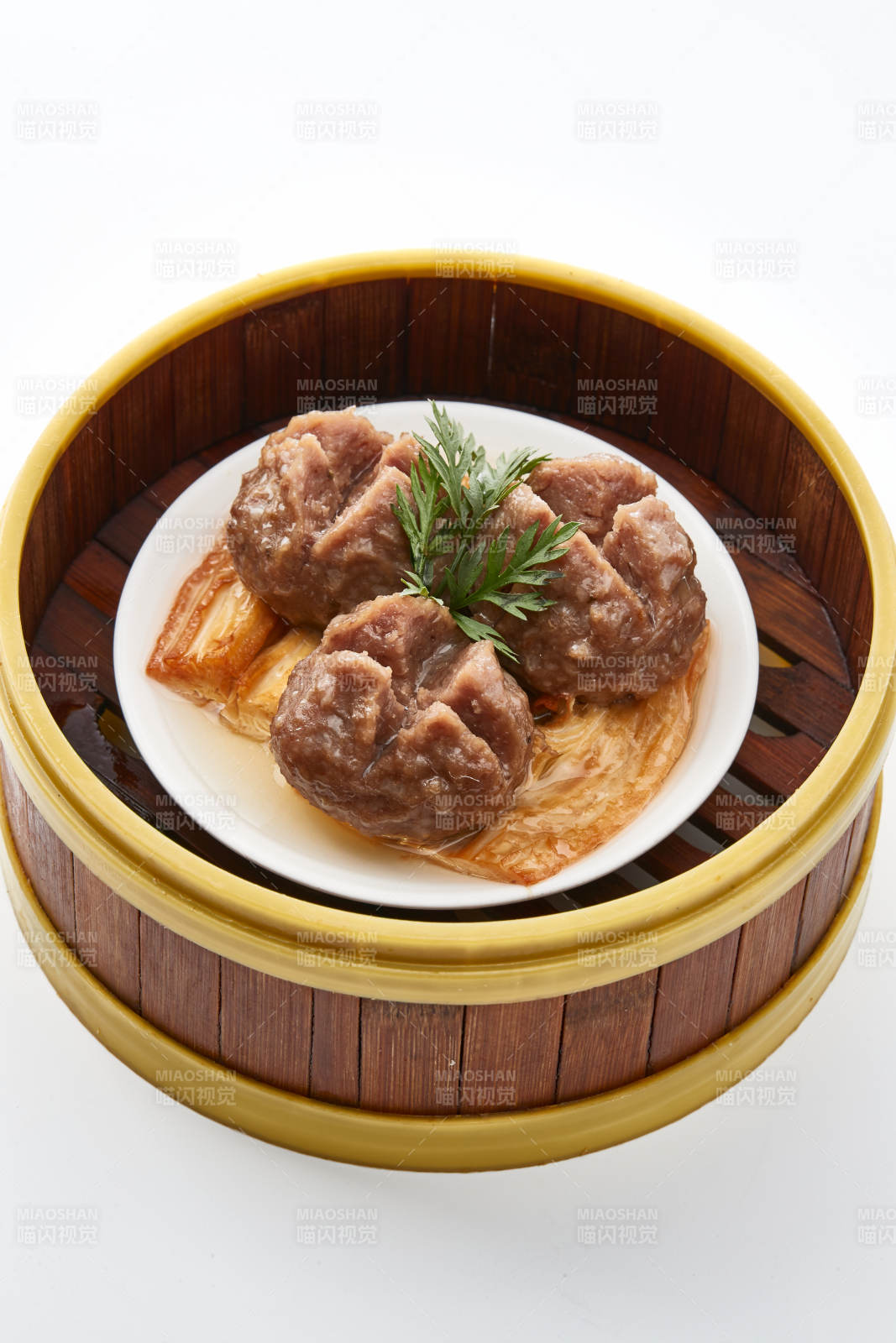 白色背景上精美竹笼屉装的开花牛肉球