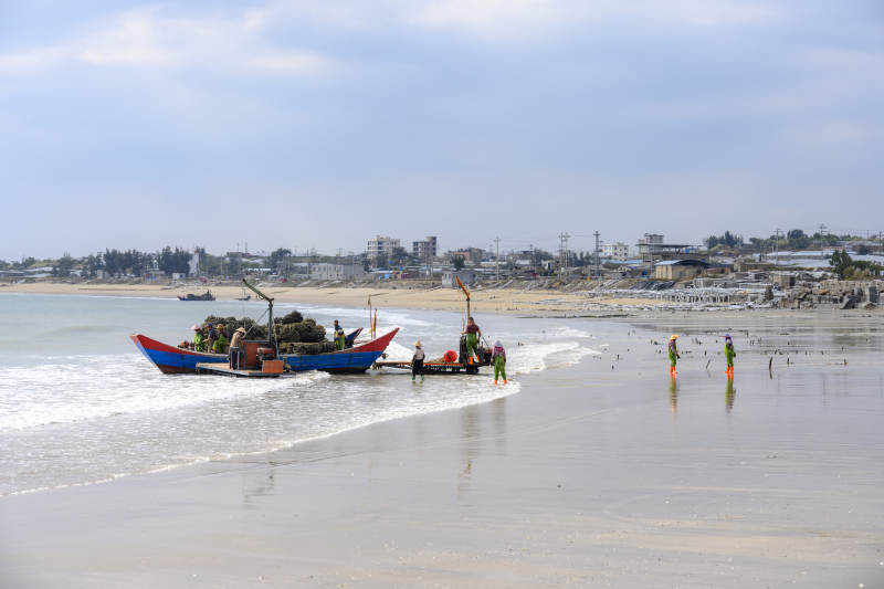 渔舟靠岸 沙滩人影