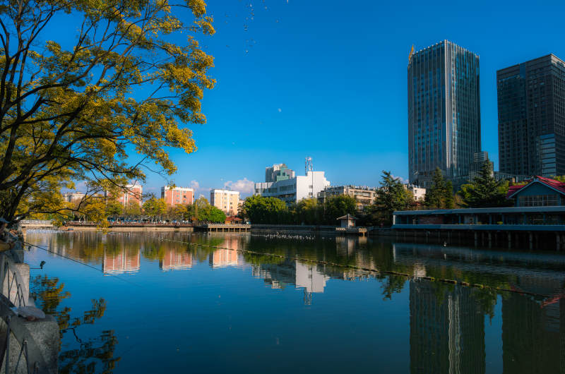 早晨的昆明大观河河畔城市倒影