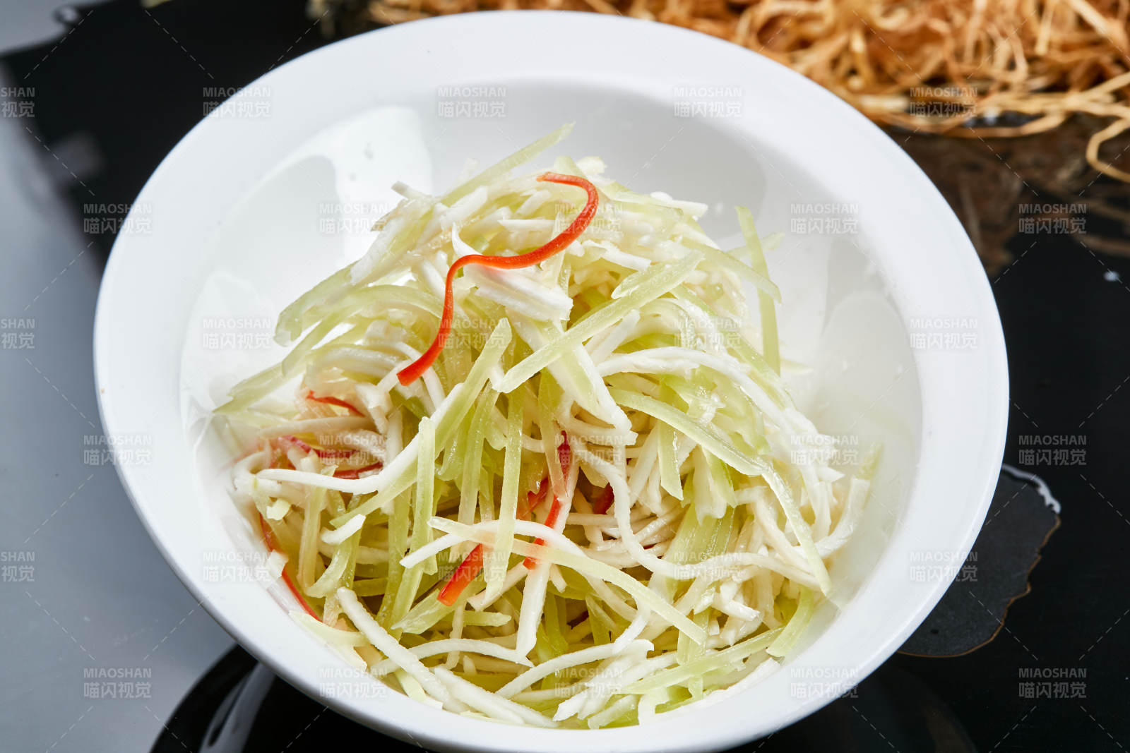 白色瓷盘装的巧拌双丝西芹丝土豆丝