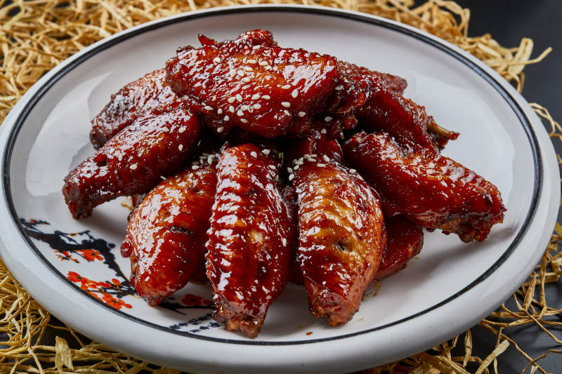 圆形瓷盘装的秘制酱烧鸡翅中