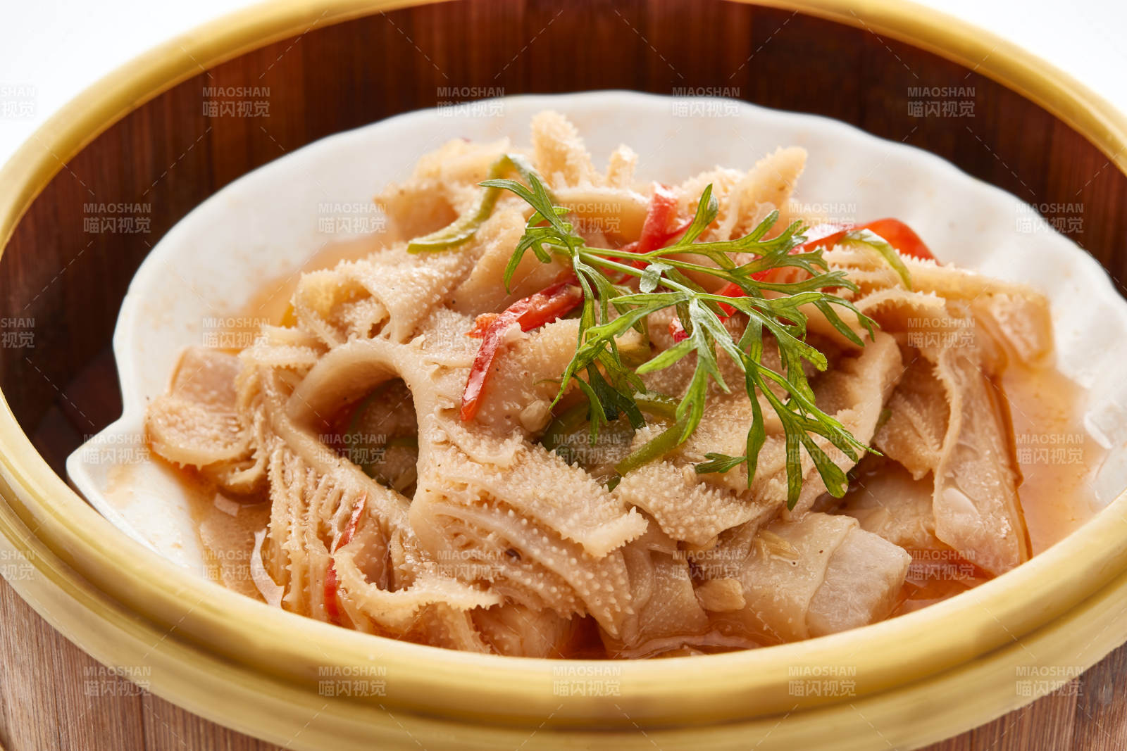 白色背景上精美竹笼屉装的港式蒸肚丝