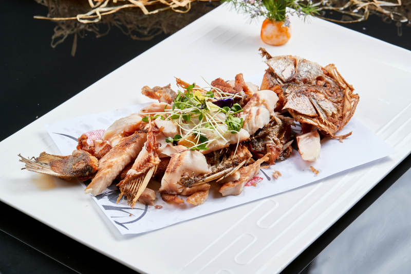 白色瓷盘装的手撕烟熏海鲈鱼