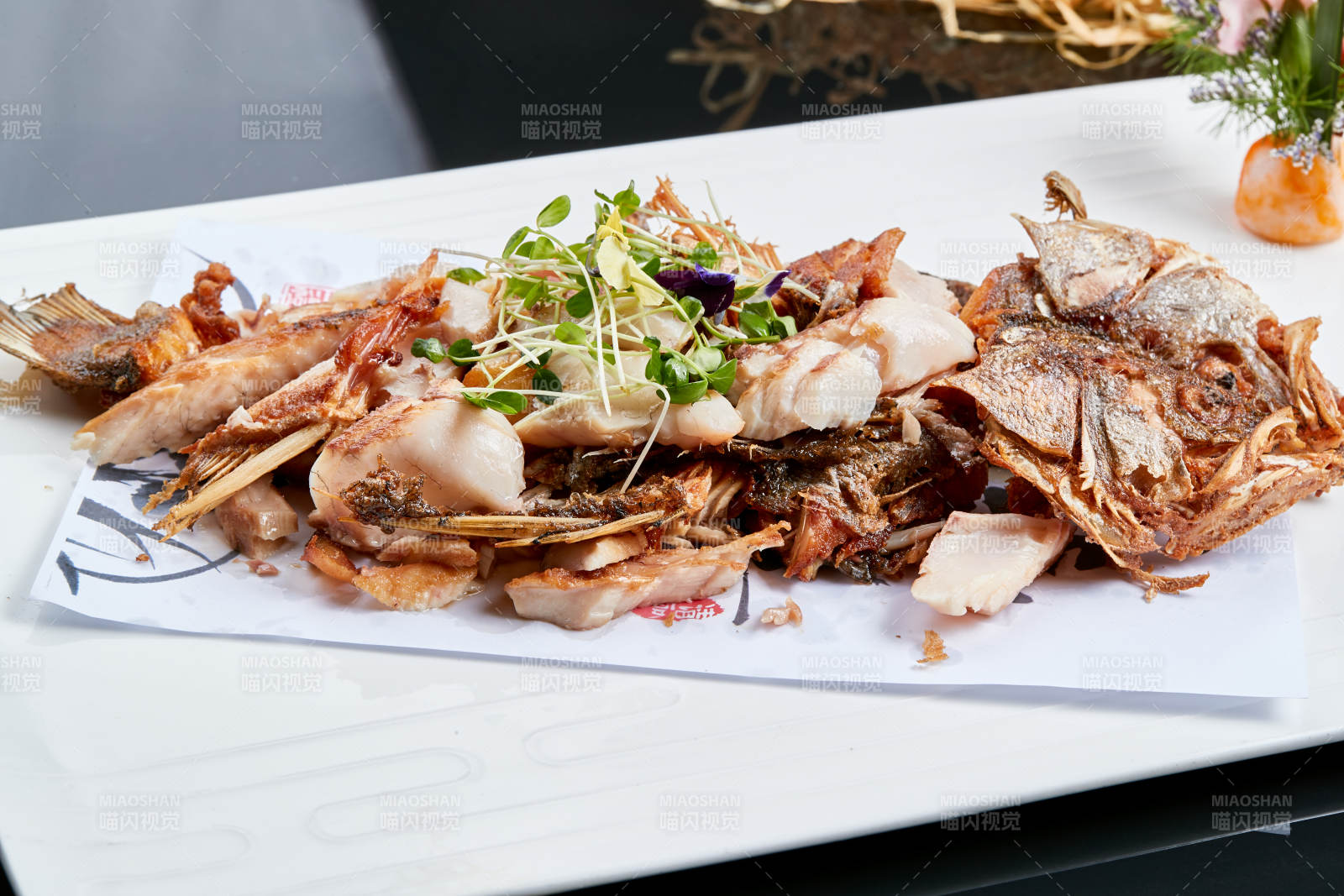 白色瓷盘装的手撕烟熏海鲈鱼