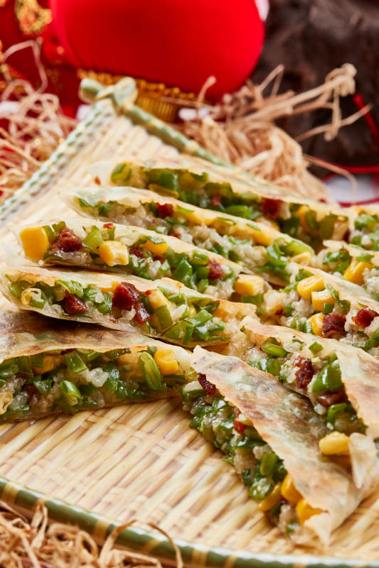 竹子笸箩装的江米牛肉玉米野菜饼