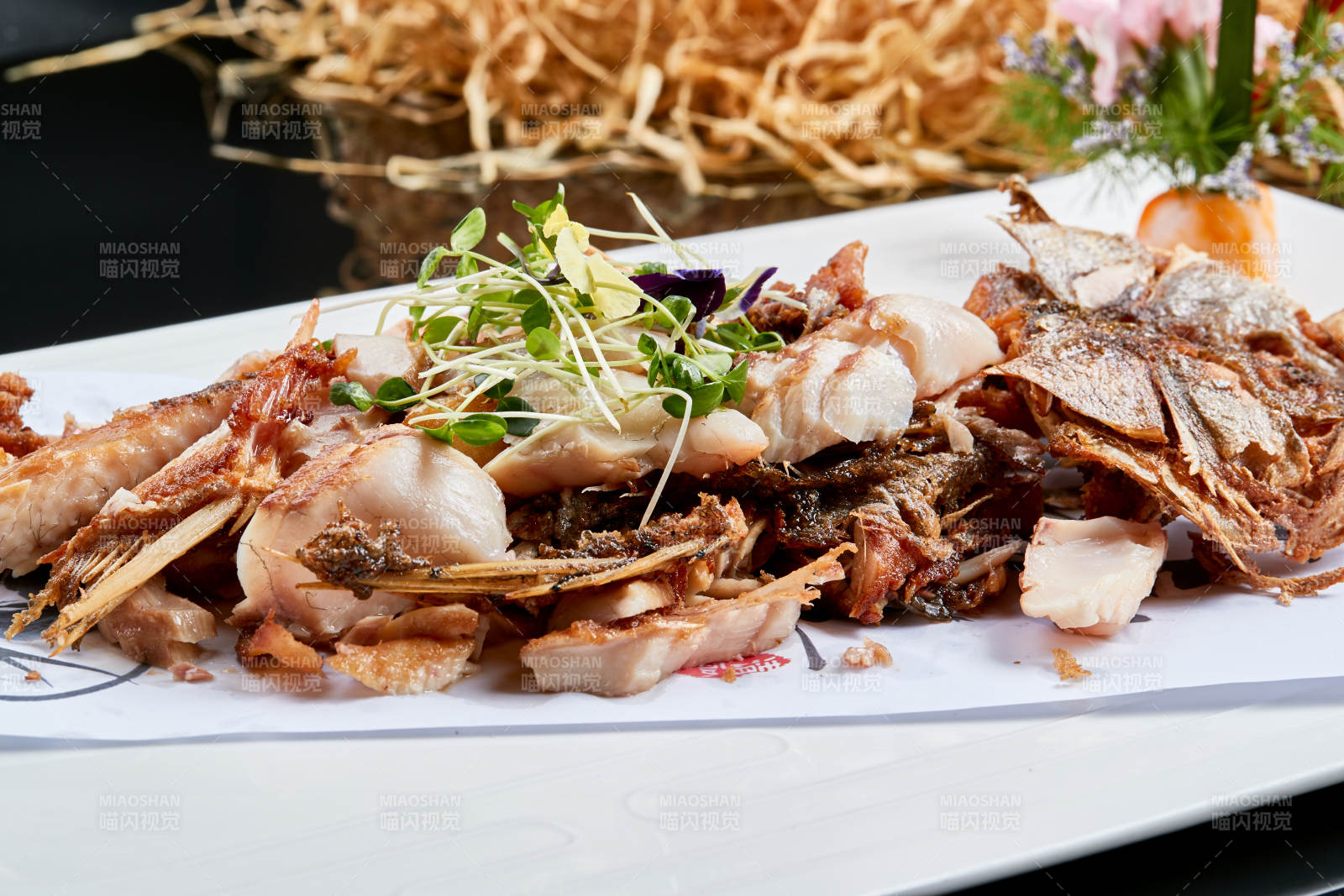 白色瓷盘装的手撕烟熏海鲈鱼