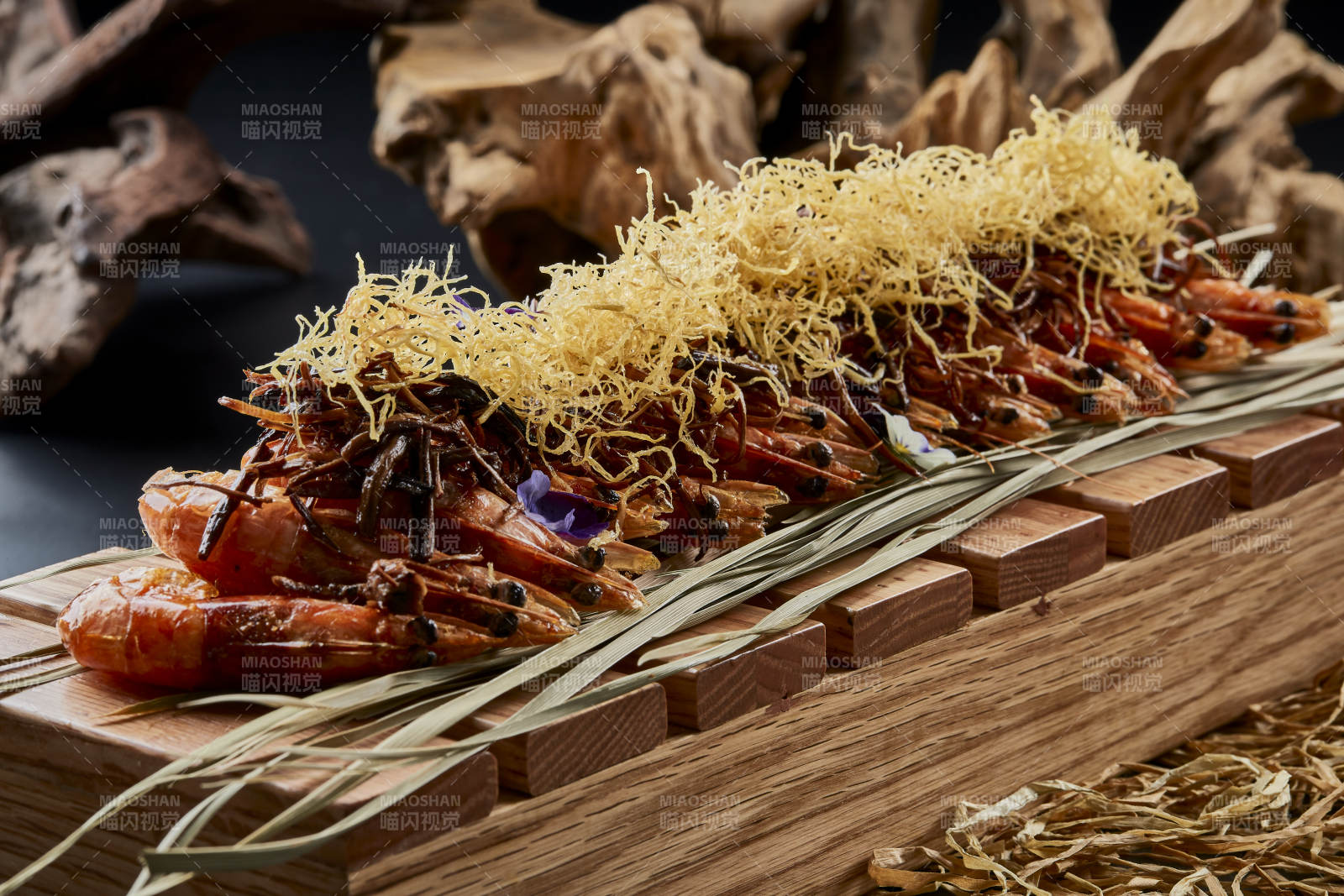 木质餐具上摆放的薯丝梅菜焗大明虾