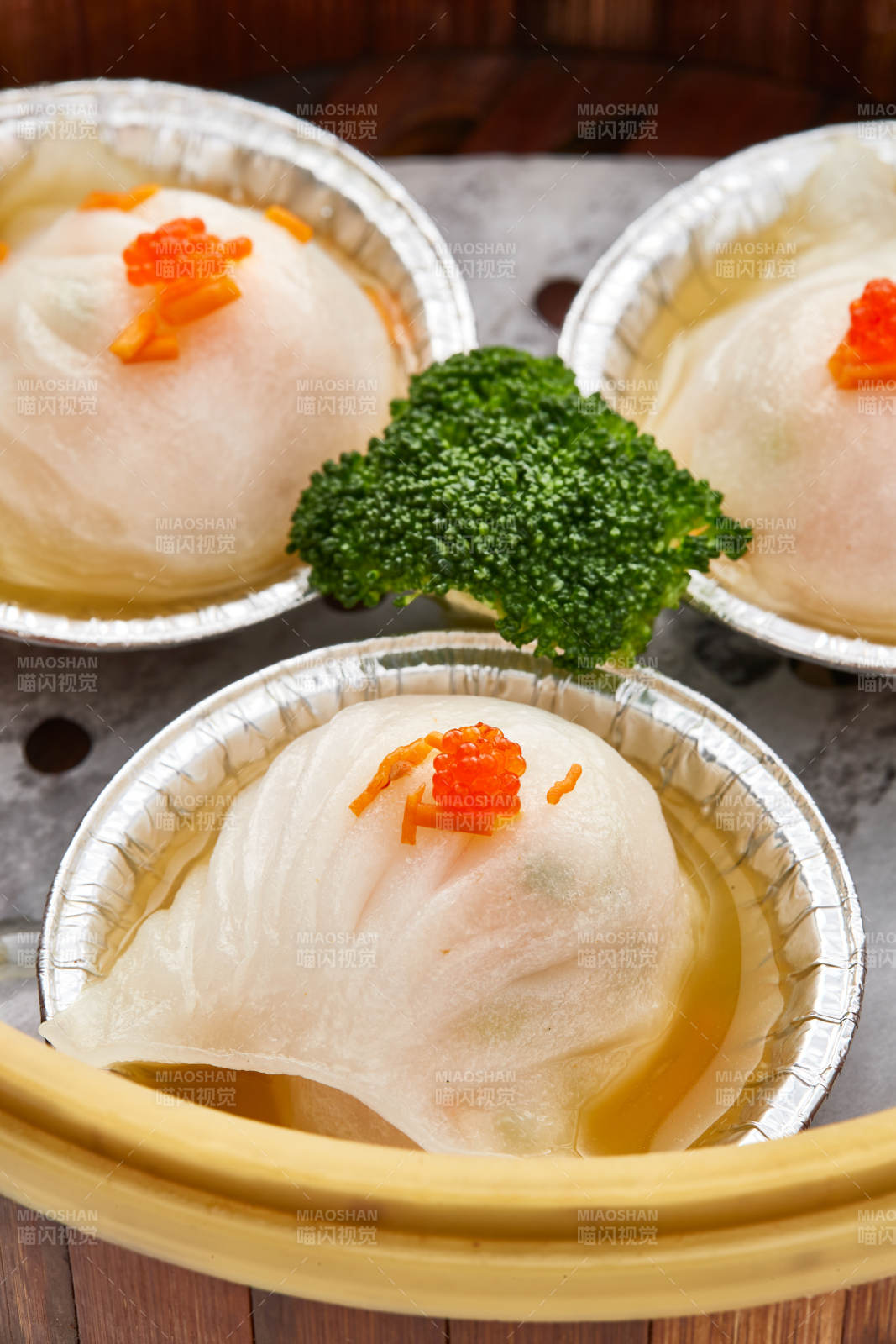 白色背景下精美竹笼屉装的港式茶餐蒸虾饺