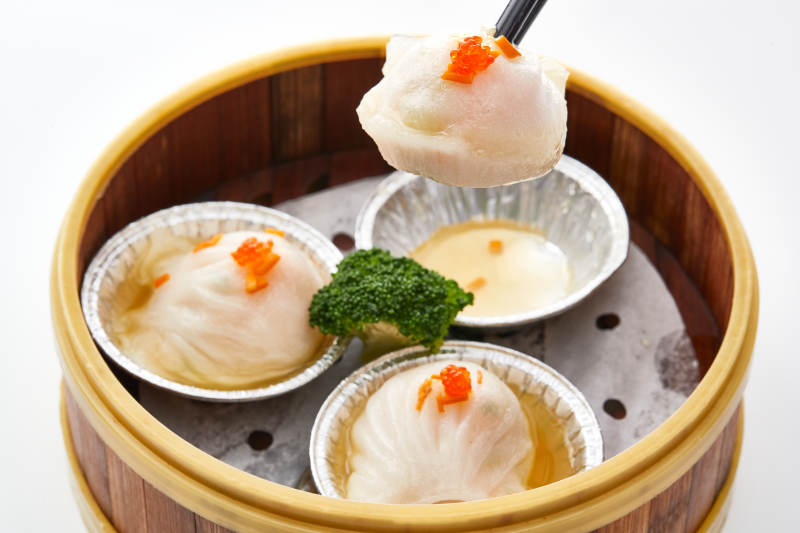 白色背景下精美竹笼屉装的港式茶餐蒸虾饺