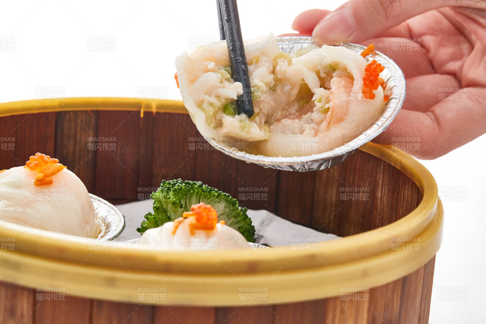 白色背景下精美竹笼屉装的港式茶餐蒸虾饺