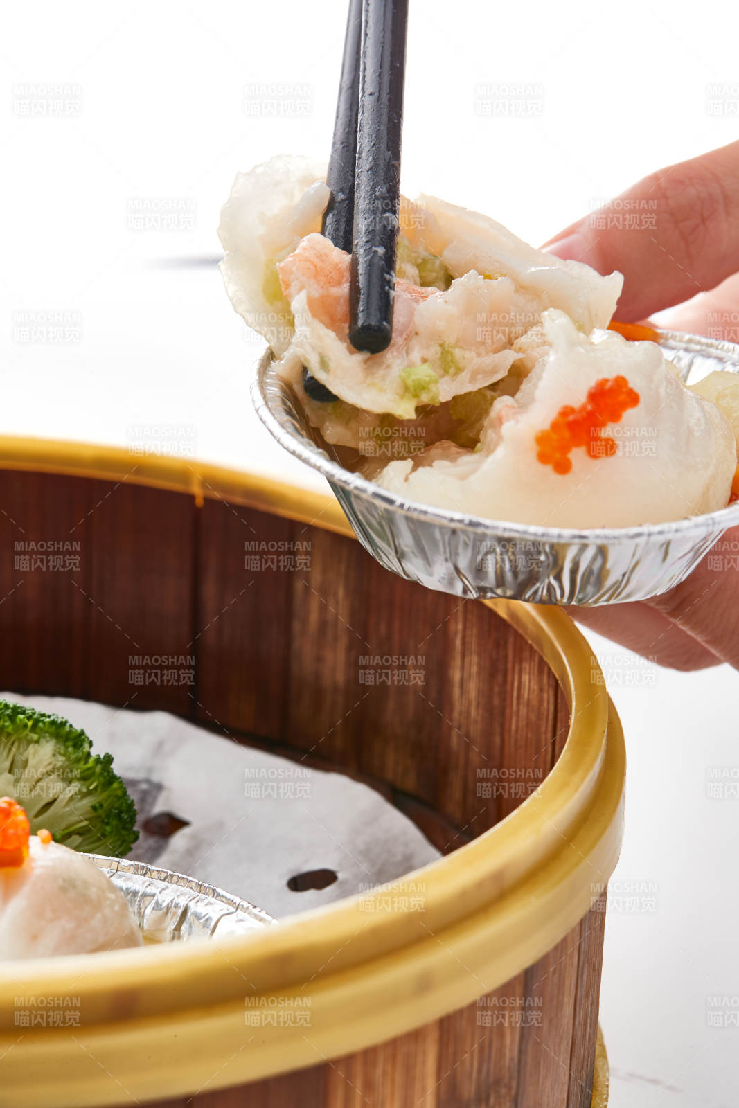 白色背景下精美竹笼屉装的港式茶餐蒸虾饺