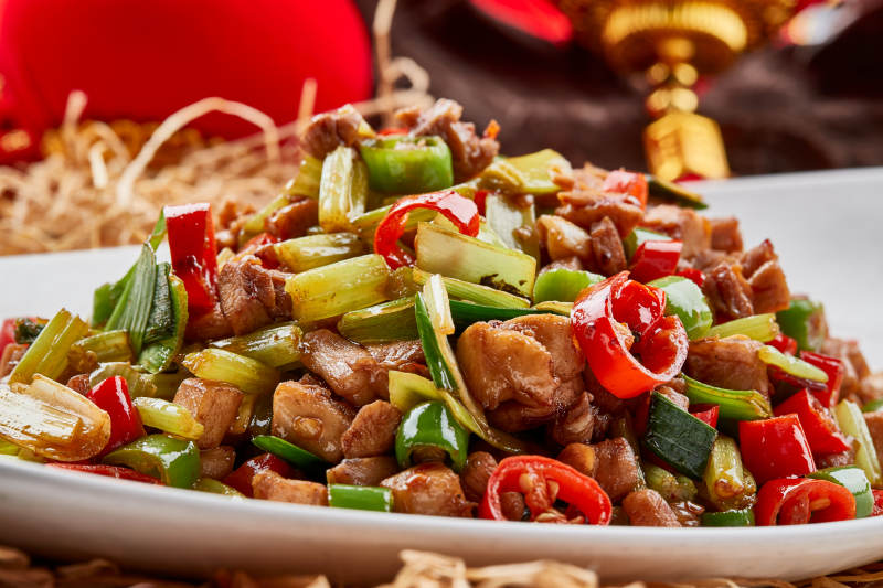 白色瓷盘装的的香辣西芹炒兔丁