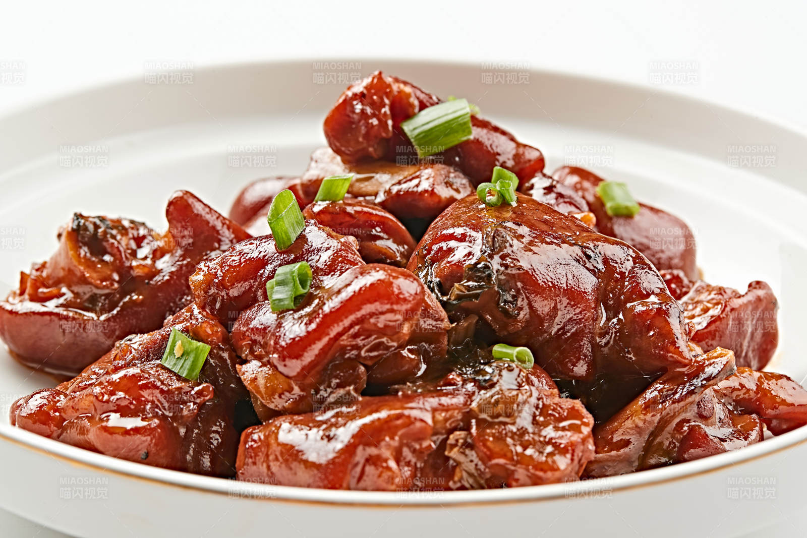 白色瓷盘装的酱香红烧猪蹄块