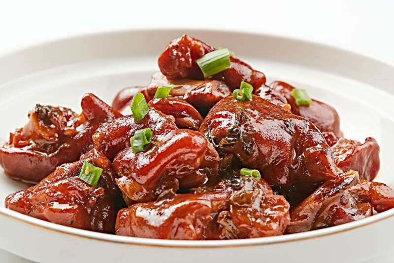 白色瓷盘装的酱香红烧猪蹄块