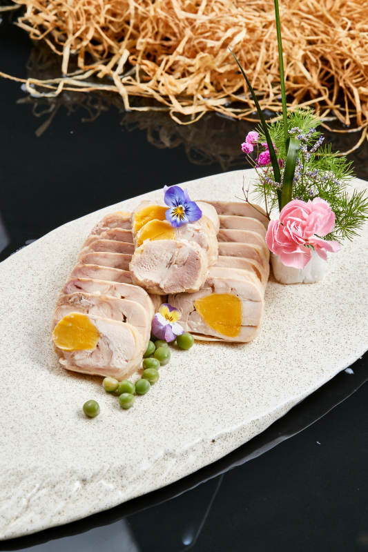 精美餐具装的鸡胸肉压咸蛋黄切片