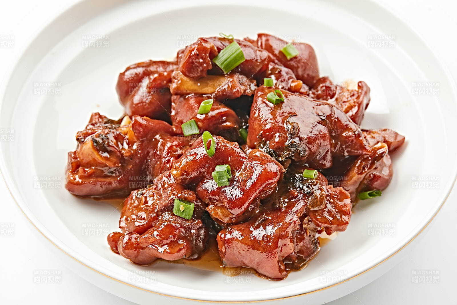 白色瓷盘装的酱香红烧猪蹄块