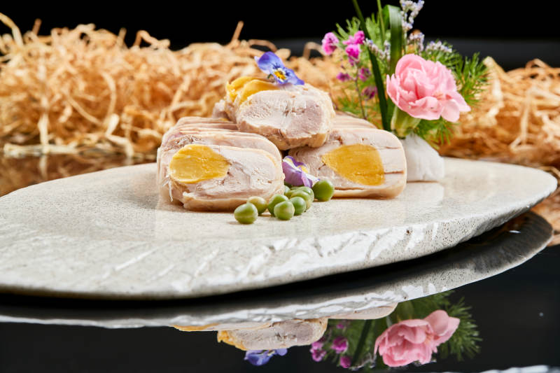 精美餐具装的鸡胸肉压咸蛋黄切片
