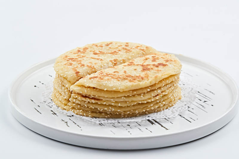 白色瓷盘装的现烙葱油酥饼