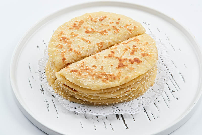 白色瓷盘装的现烙葱油酥饼