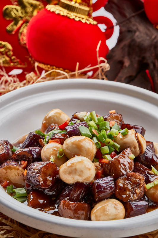 白色砂锅装的香辣鹌鹑蛋茄子煲