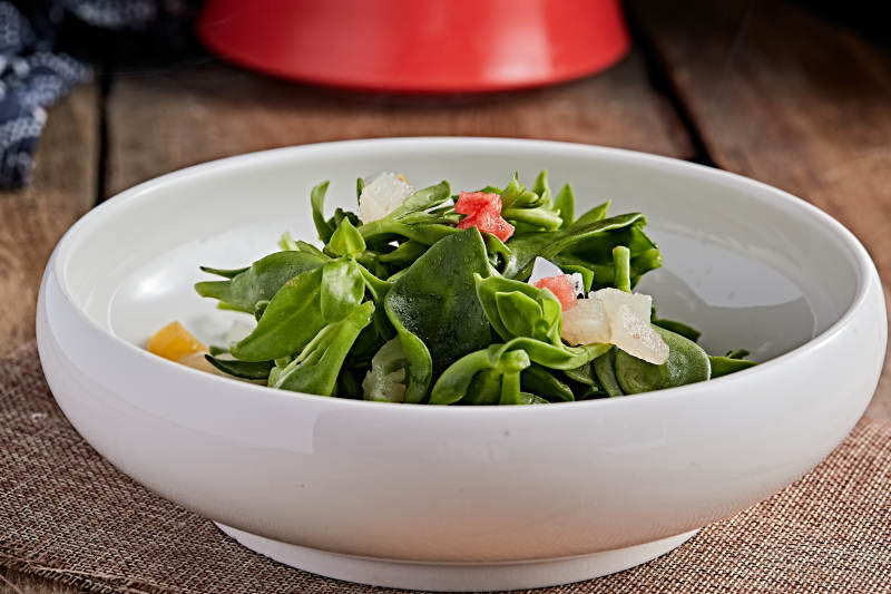 白色瓷盘装的的水果粒炝拌穿心莲