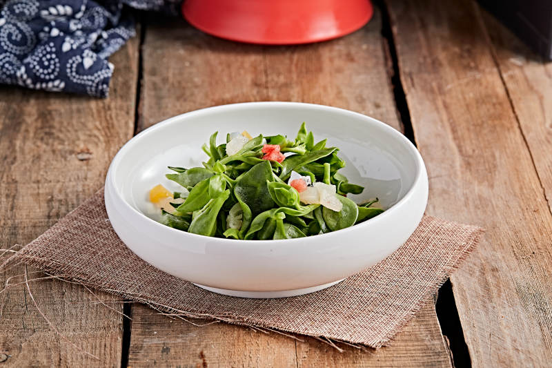 白色瓷盘装的的水果粒炝拌穿心莲