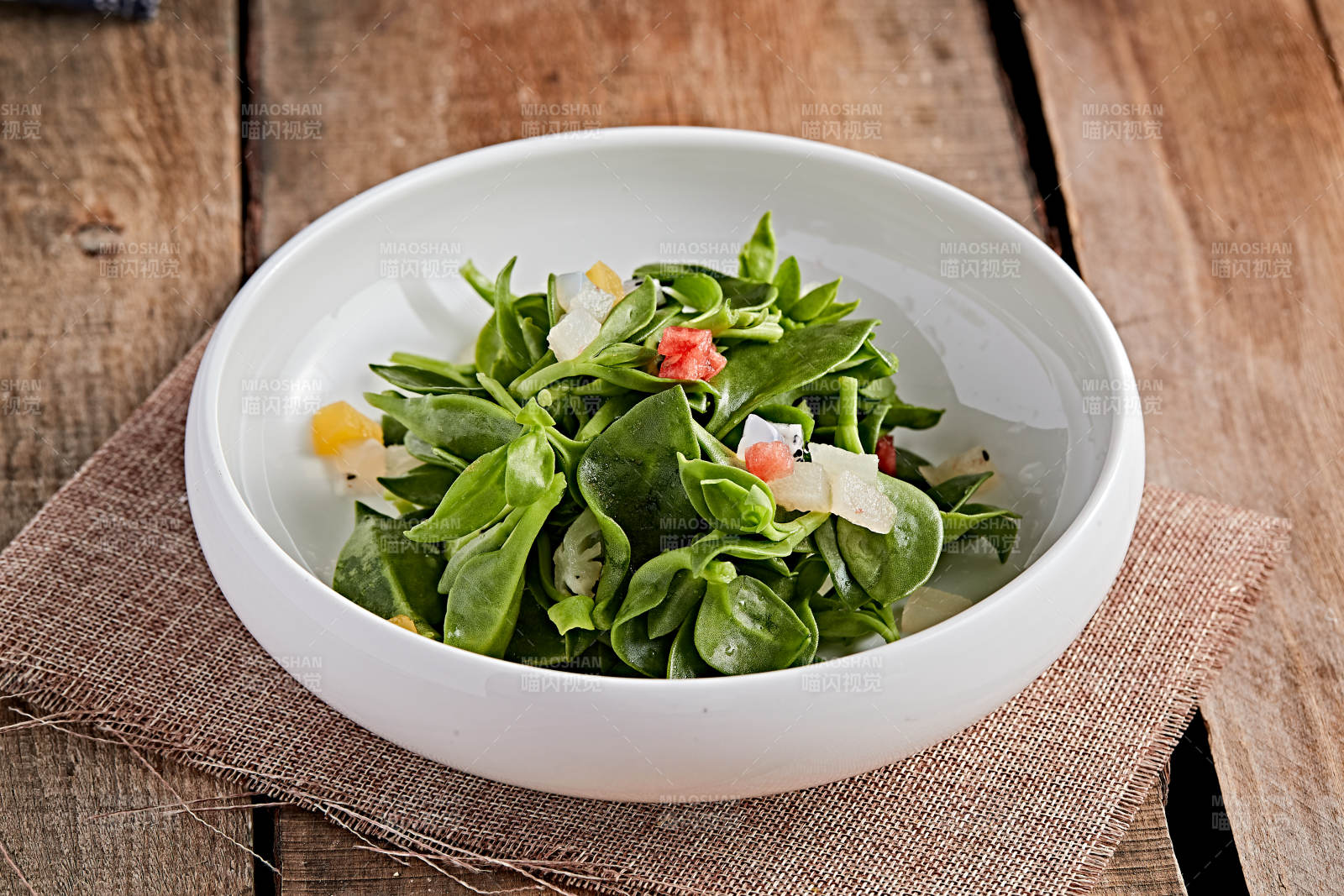 白色瓷盘装的的水果粒炝拌穿心莲