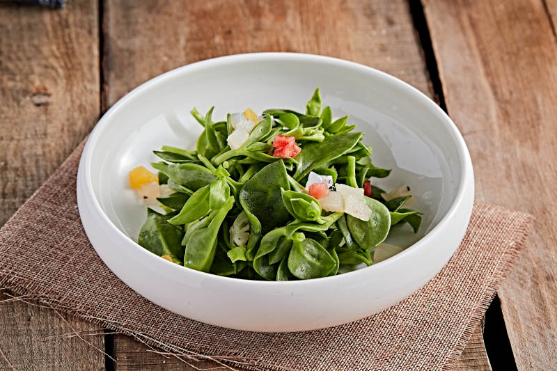 白色瓷盘装的的水果粒炝拌穿心莲