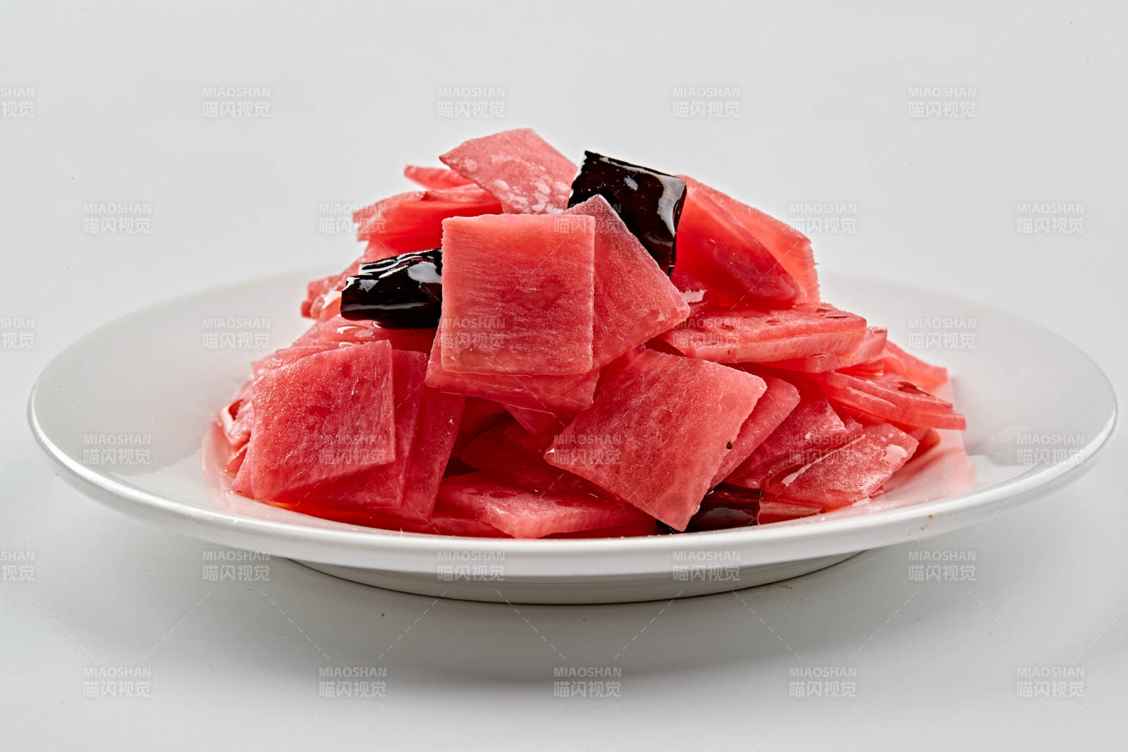 白色瓷盘装的红醋香辣萝卜皮