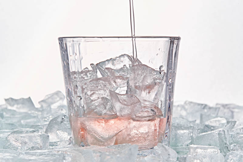 布满冰块的酒杯中的清凉桃子味预调酒