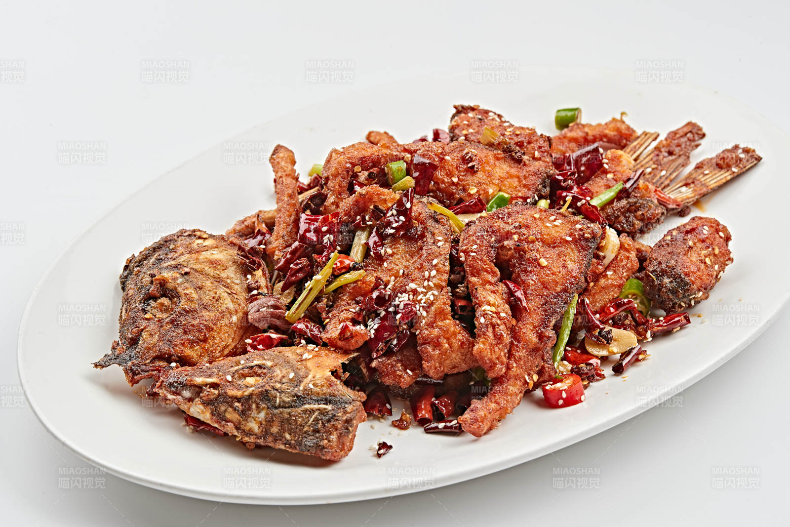 白色瓷盘装的香辣油炸大鲤鱼