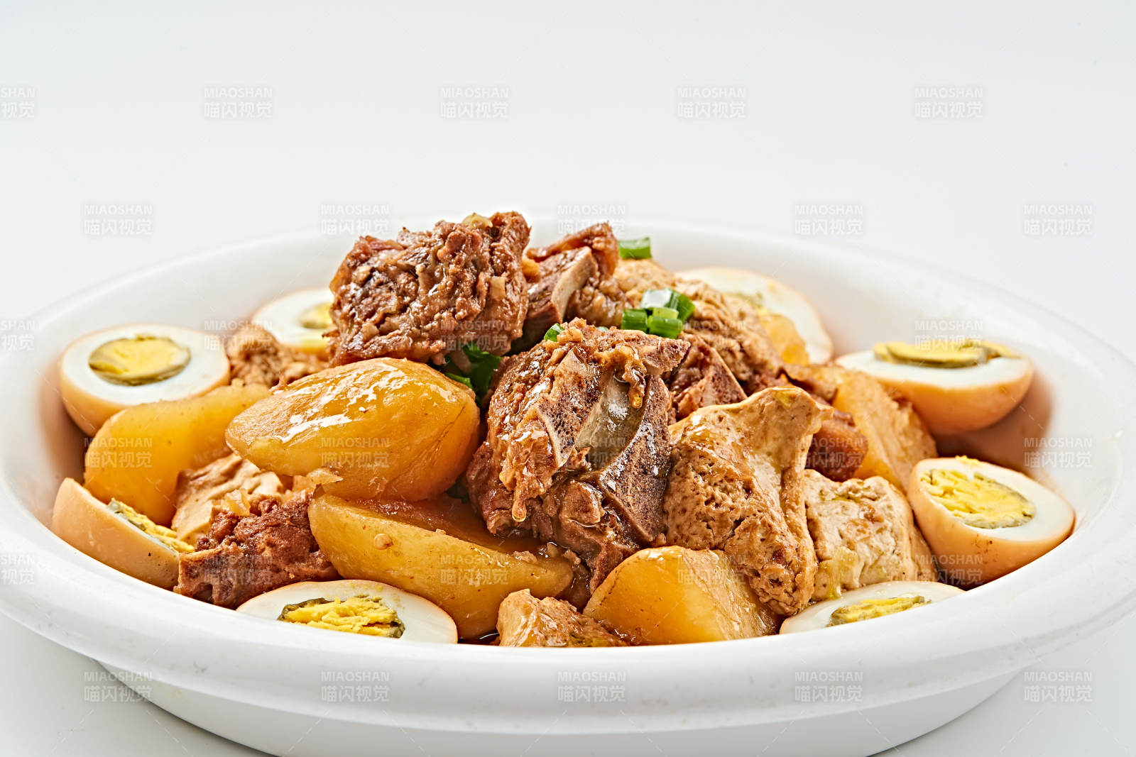 白色瓷盤(pán)裝的農(nóng)家土豆燒豬脊骨