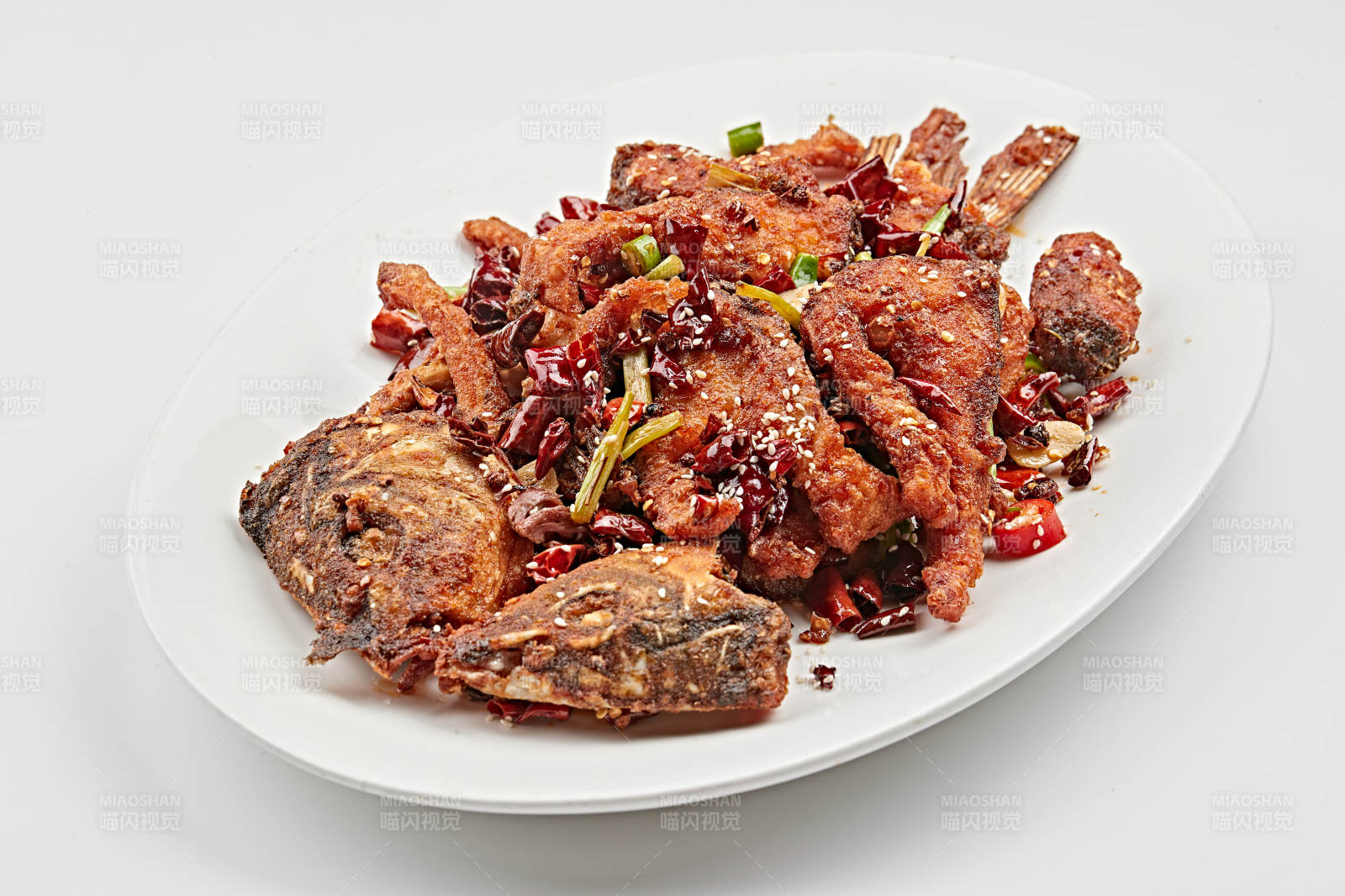 白色瓷盘装的香辣油炸大鲤鱼