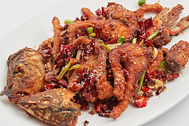 白色瓷盘装的香辣油炸大鲤鱼