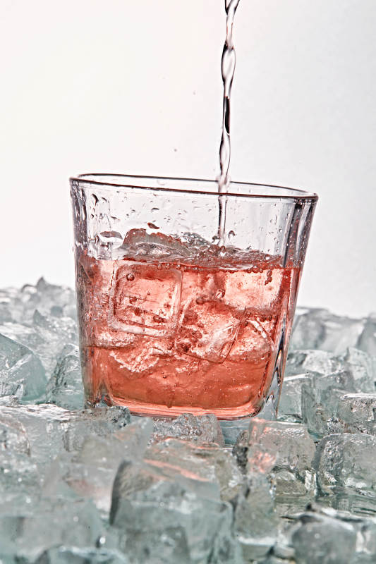 布满冰块的酒杯中的清凉桃子味预调酒