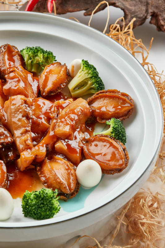 精美餐具装的浇汁鲜鲍鱼烧梅花参