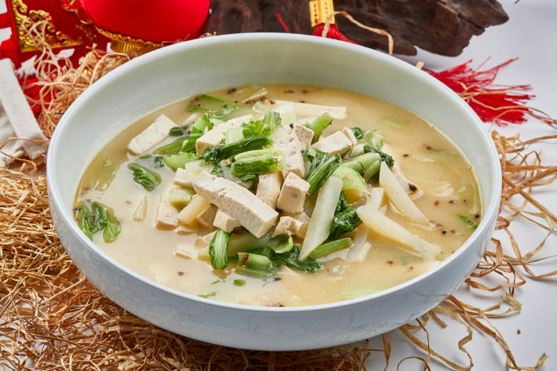 白色瓷餐具裝的濃湯小白菜土豆燉豆腐