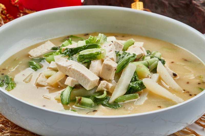 白色瓷餐具裝的濃湯小白菜土豆燉豆腐
