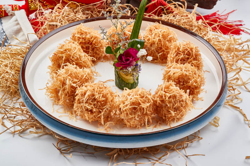 白色瓷盘装的金丝油炸大虾球