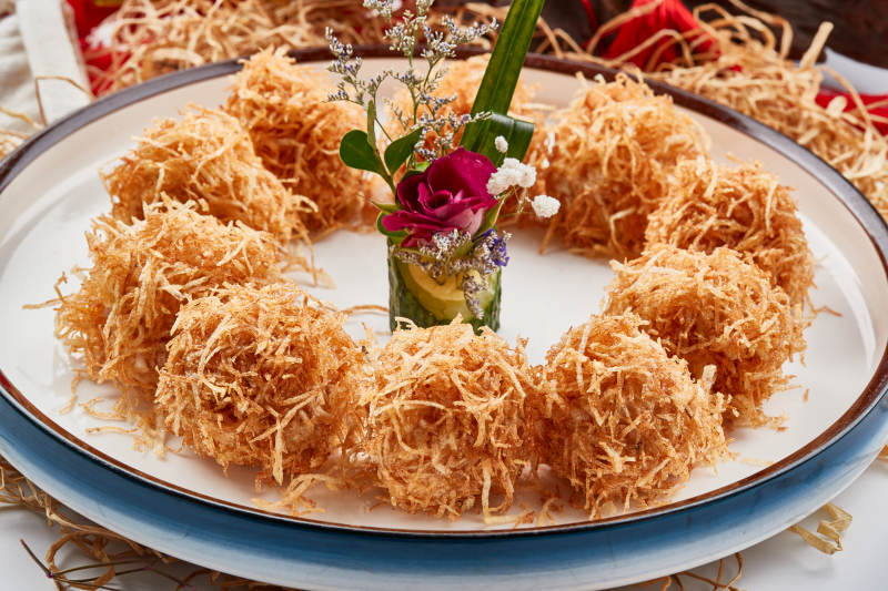 白色瓷盘装的金丝油炸大虾球