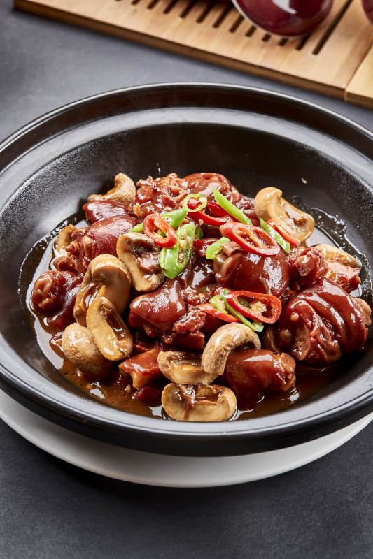 黑砂锅装的砂锅鲜口蘑烧猪脚块