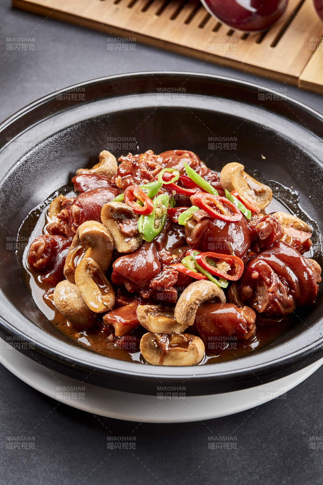 黑砂鍋裝的砂鍋鮮口蘑燒豬腳塊