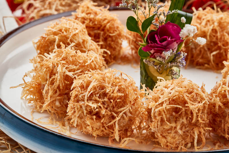 白色瓷盘装的金丝油炸大虾球