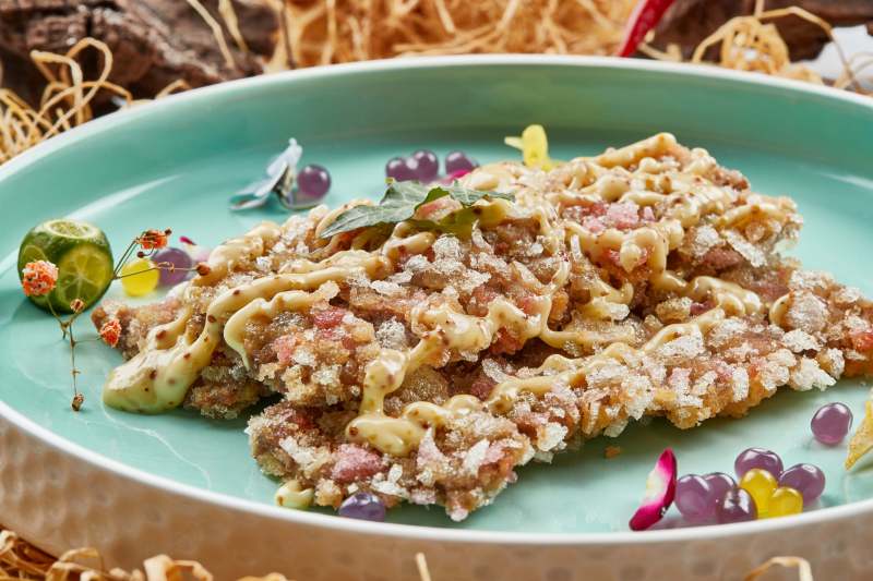 请釉瓷盘装的油炸和牛牛排配凯撒酱