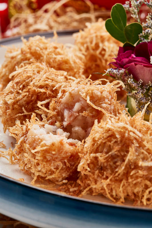 白色瓷盘装的金丝油炸大虾球