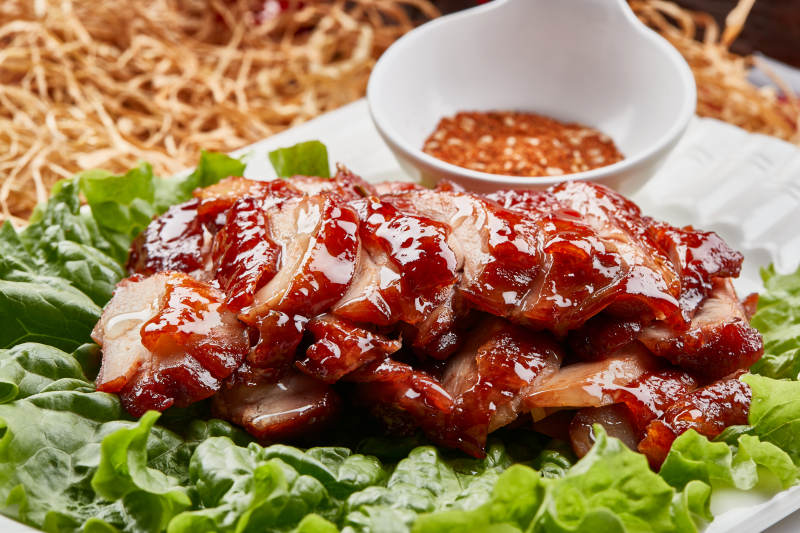 白色瓷盘装的蜜汁叉烧鸡腿肉