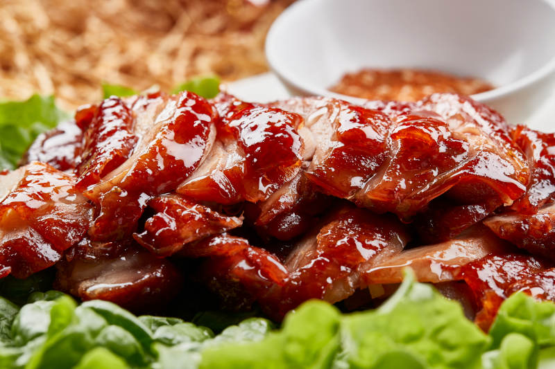 白色瓷盘装的蜜汁叉烧鸡腿肉