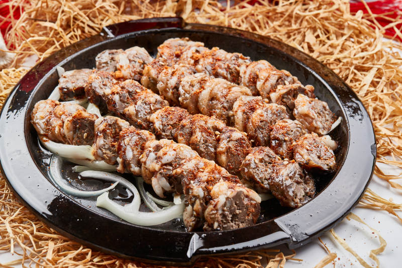 黑色铁盘装的香烤裹油羊肝