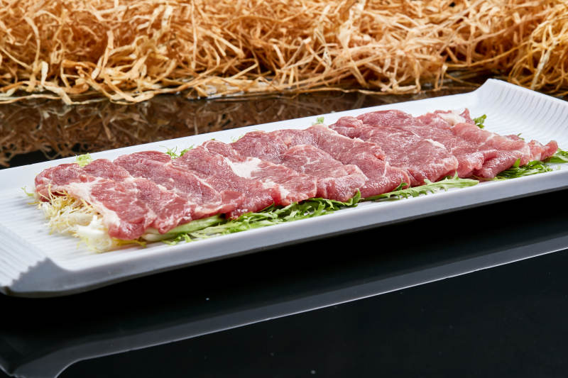 白色瓷盘装的的韩式烤肉食材猪梅肉