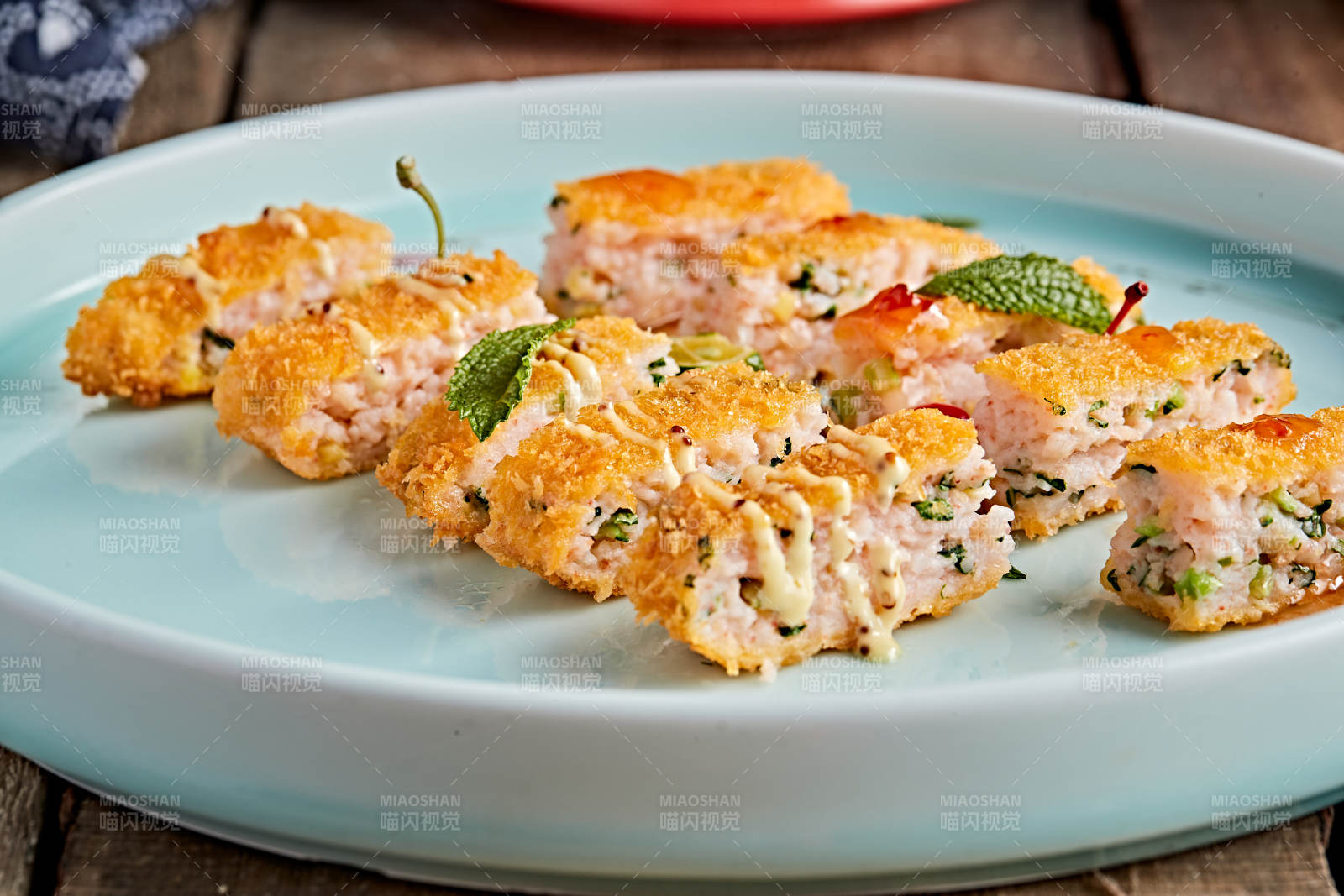 青色瓷盘装的油炸黄金虾饼